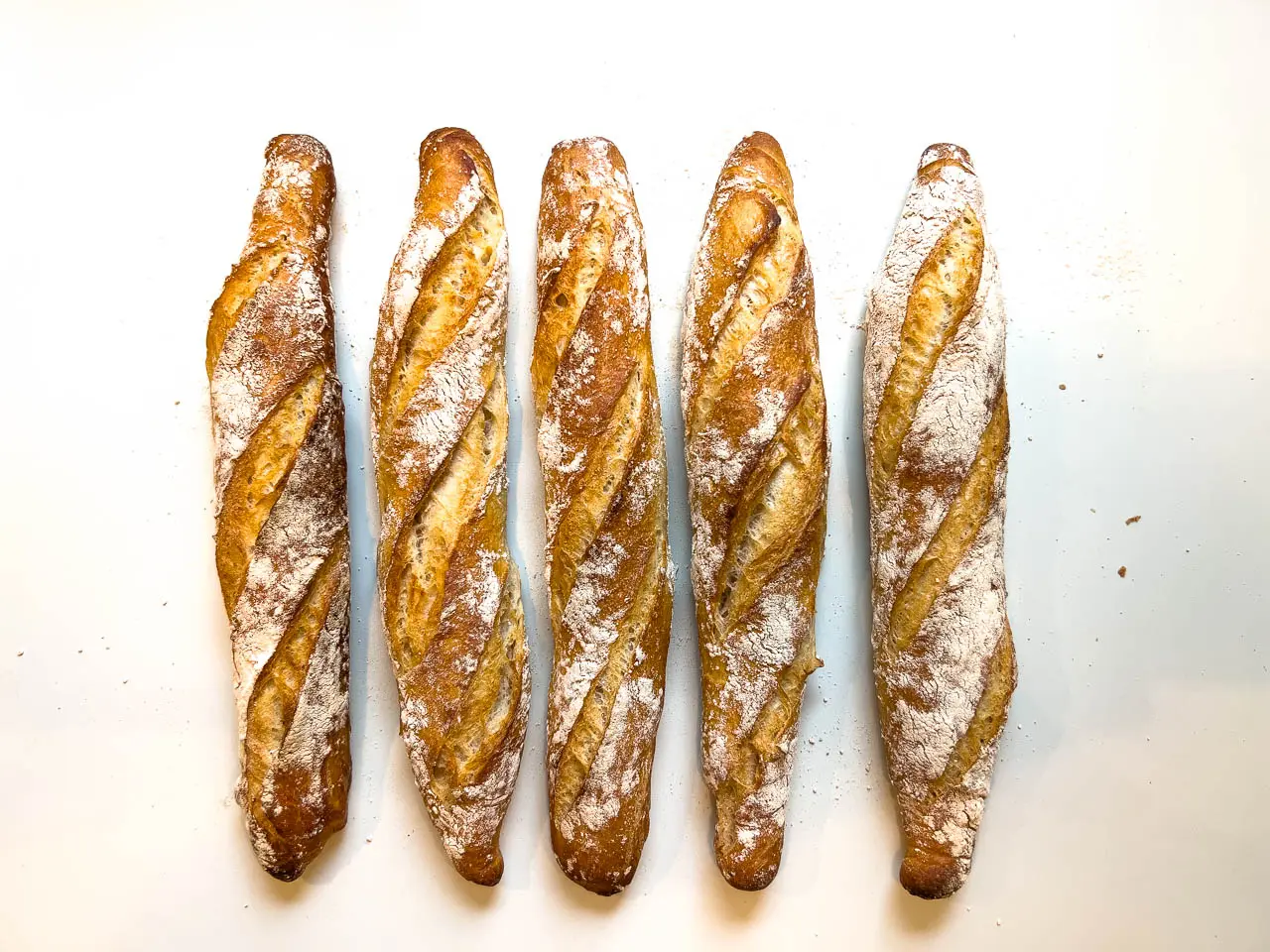 Fünf frische Baguette mit Sauerteig, bestreut mit Mehl