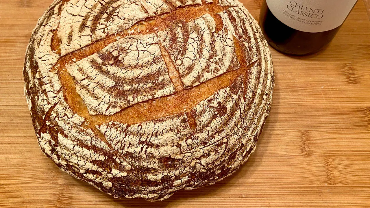 Ein frisch gebackenes Sauerteigbrot neben einer Weinflasche